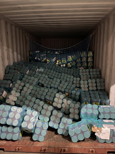 The shipment of shrink-wrapped beverage cases has completely collapsed and shifted forward inside the container.