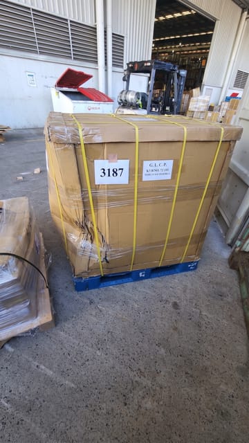 The large cardboard container has a severely crushed and buckled lower-left corner.